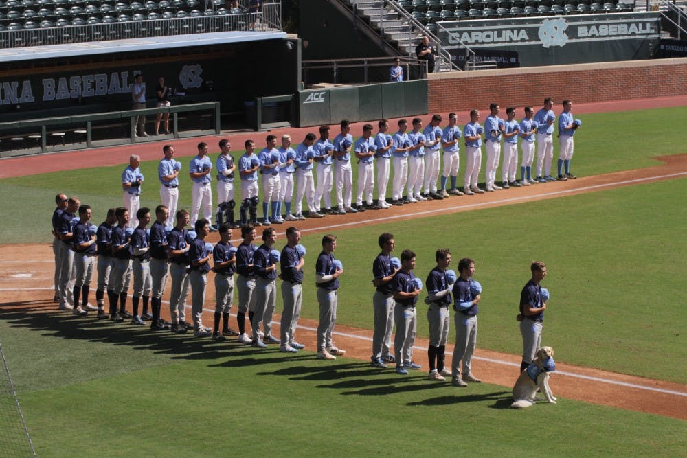 The North Carolina baseball team stands for the national anthem before its Fall World Serie intrasquad scrimmage on Sunday afternoon.