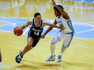Duke senior guard Jordan Goldwire (14) dribbles past UNC first year guard Kerwin Walton (24) during a game against Duke in the Smith Center on Saturday, March 6, 2021. 