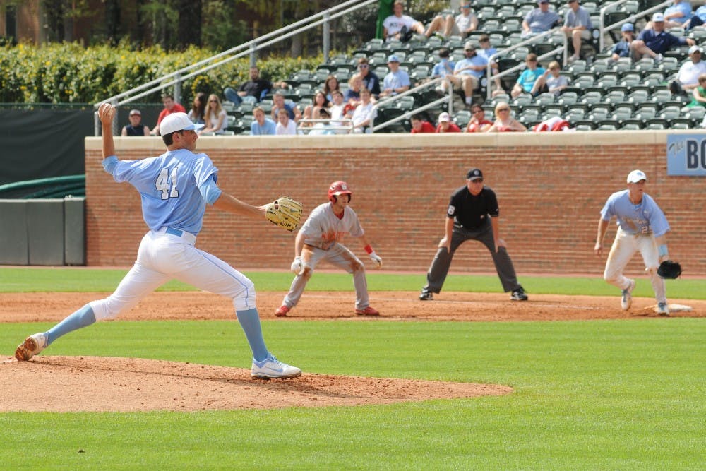 Left handed pitcher Kent Emanuel (41) throws a pitch as Cody Stubbs (25) hold on a NC State runner in Carolina's 3-1 loss to NC State at Boshamer Stadium in Chapel Hill Saturday, March 24th. 