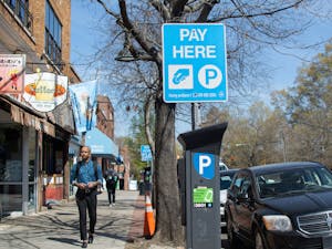 Pedestrians pass a parking meter on Franklin Street on Tuesday, March 21, 2023.