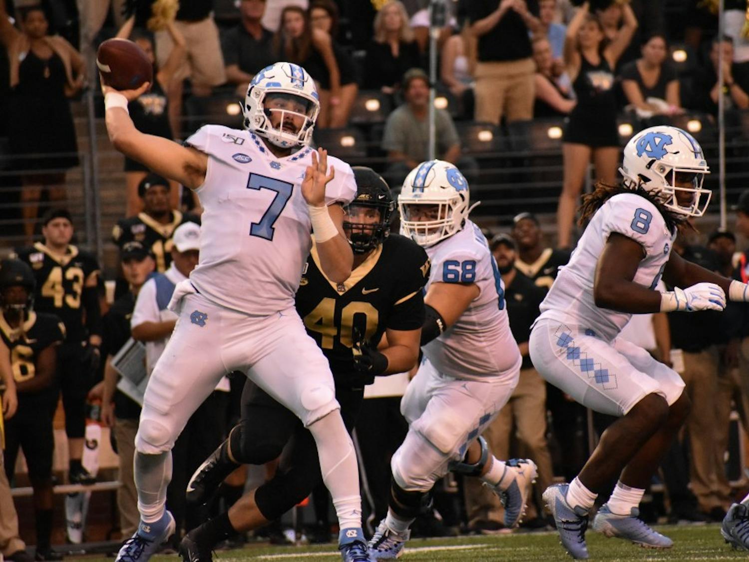 UNC-CH first-year quarterback Sam Howell (#7) winds up a throw to one of his teammates as the Wake Forest defense closes in. 