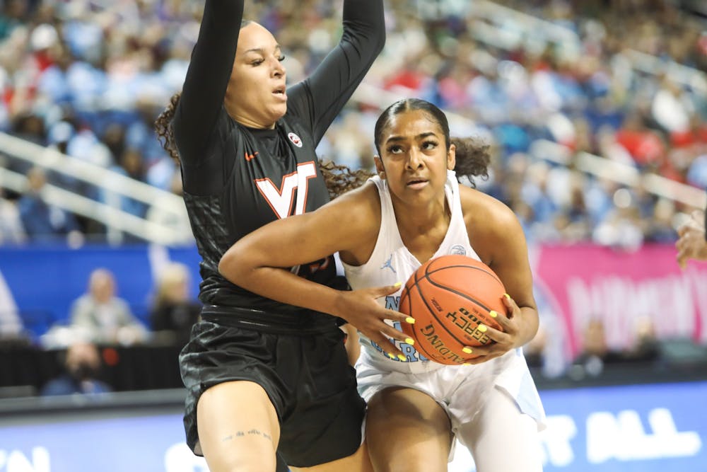 UNC sophomore guard Deja Kelly (25) attempts to surpass an offender for a layup during the quarterfinals of the ACC Women's Basketball Tournament against Virginia Tech at the Greensboro Coliseum. Virginia Tech won 87-80 in overtime.