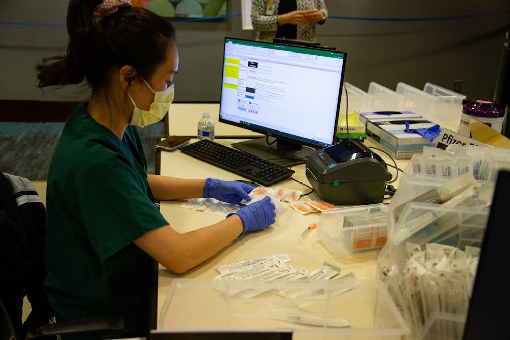 Fourth year pharmacy student Hannah Kim prepares syringes at the end of a day of of vaccinations at the Friday Center on Monday, Mar. 22, 2021.