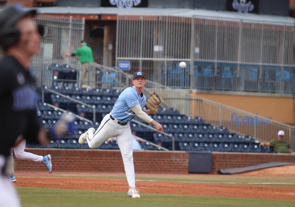 Infielder Mac Horvath (10) passes the ball to first base as a Duke player runs towards it. The Heels beat Duke 10-5 away on Friday, March 18, 2022.