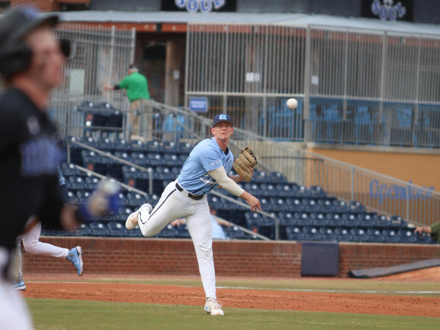 Infielder Mac Horvath (10) passes the ball to first base as a Duke player runs towards it. The Heels beat Duke 10-5 away on Friday, March 18, 2022.