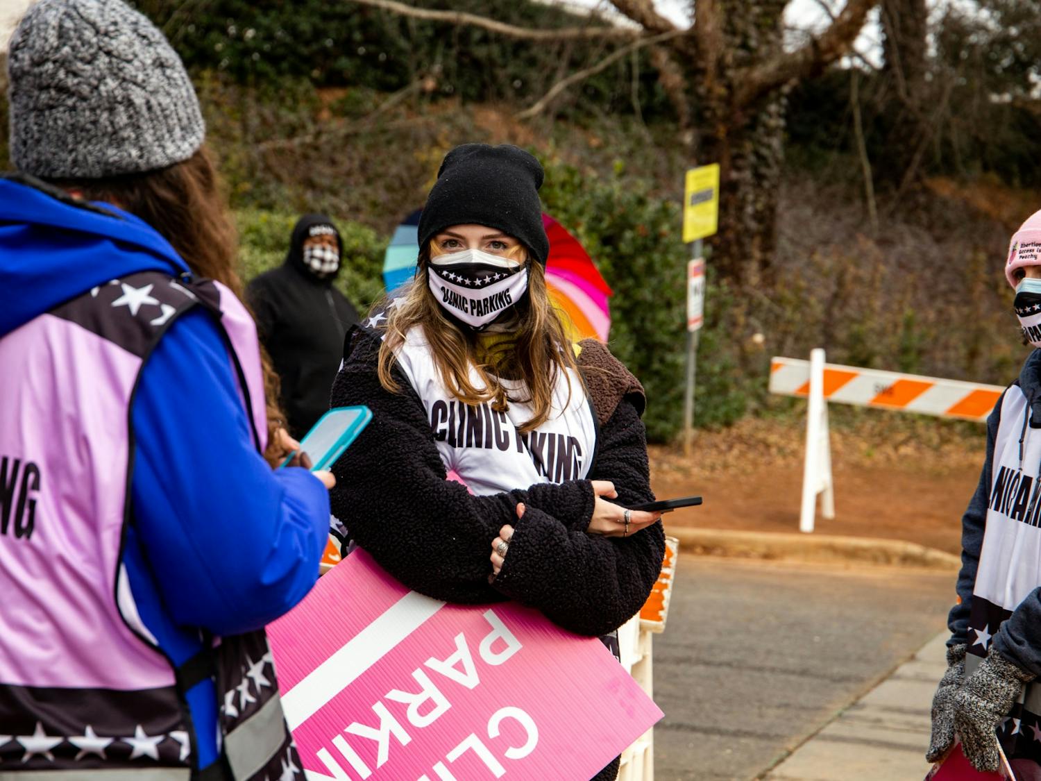 UNC student Reiley Baker stands among other volunteers at A Preferred Women's Health Center of Charlotte, only a few yards from the group of evangelical, anti-abortion activists who protest daily outside the clinic. 