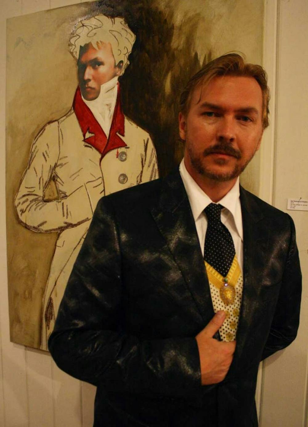 The artist Louis St. Lewis poses with a self-portrait in his gallery display at Toots &amp; Magoo.