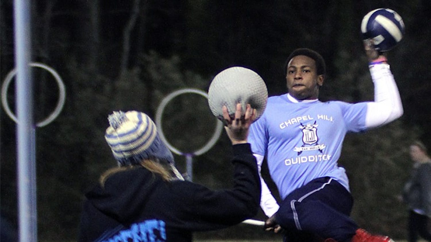 Lee Hodge jumps before attempting to score while Jessica McAfee defends during a Wednesday night quidditch practice.
