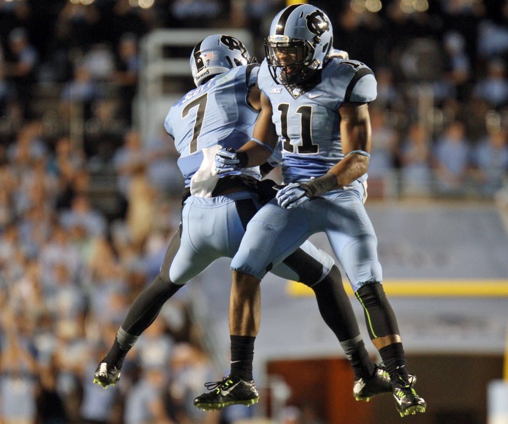 Malik Simmons (11) and Tim Scott celebrate after the defense forced a fumble and recovered possession.