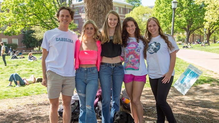 UNC junior Evan Johnson (left), senior Madeline Sussman, sophomore Abby Behringer, sophomore Caroline Smith and junior Kennadi Bernard (right) are executive members of Carolina Puppies Unite People. They pose with Lucia,. one of the many dogs that socialize with students on campus, at Polk Place on Tuesday, April 11, 2023.&nbsp;
