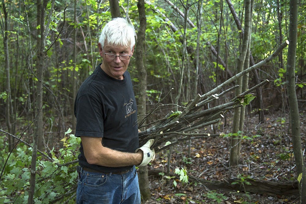 Environmental artist Patrick Dougherty hauls young maple trees and small branches on land at the Hillsborough District Headquarters for the North Carolina Forest Service to use for his stick work installation at the North Carolina Botanical Garden. Dougherty, a 1967 graduate of UNC, said that it's a "big challenge" to find wood that's locally sourced.