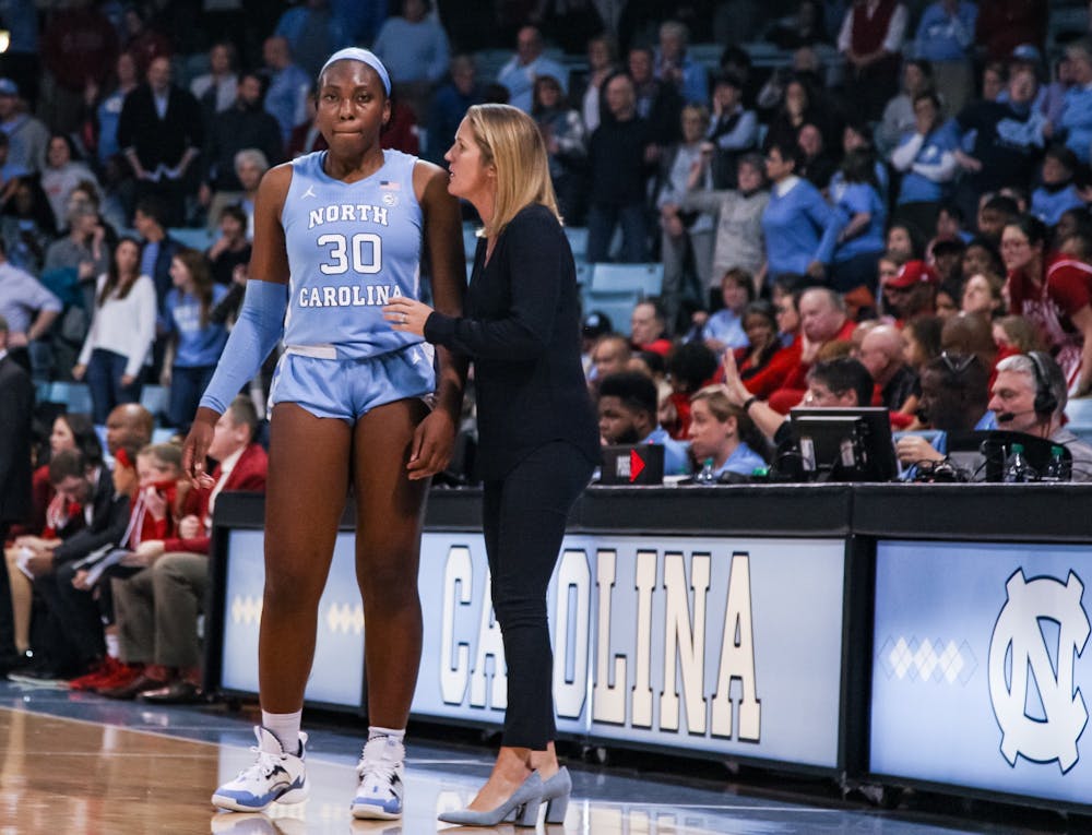 <p>UNC's women's basketball coach Courtney Banghart talks with junior center Janelle Bailey (30) during a game against N.C. State on Thursday, Jan. 9, 2020. UNC broke NC State's undefeated streak with a score of 66-60.</p>