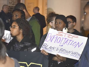 A coalition of students protest and interrupt Carol Folt at a meeting at town hall on Nov. 19, 2015. They read a list of demands that call for change at universities worldwide.