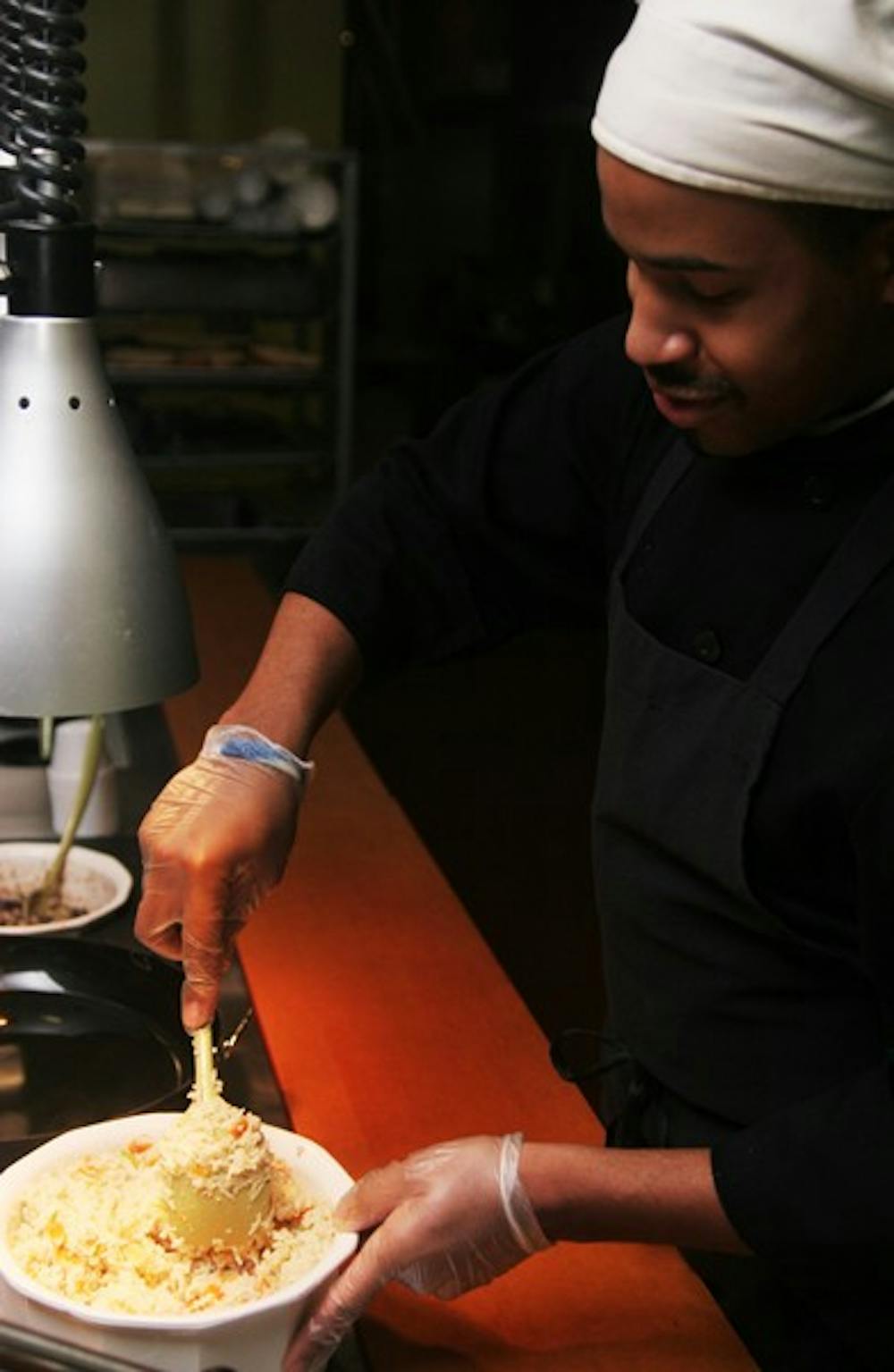 Joshua Holland stirs up a rice mixture at of 1.5.0., the newest restaurant in Lenoir Mainstreet. DTH/Margaret Cheatham Williams