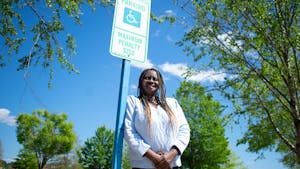 Darice Johnson, a disabled veteran, is pictured with an accessible parking sign on Tuesday, April 19, 2022.