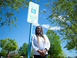 Darice Johnson, a disabled veteran, is pictured with an accessible parking sign on Tuesday, April 19, 2022.