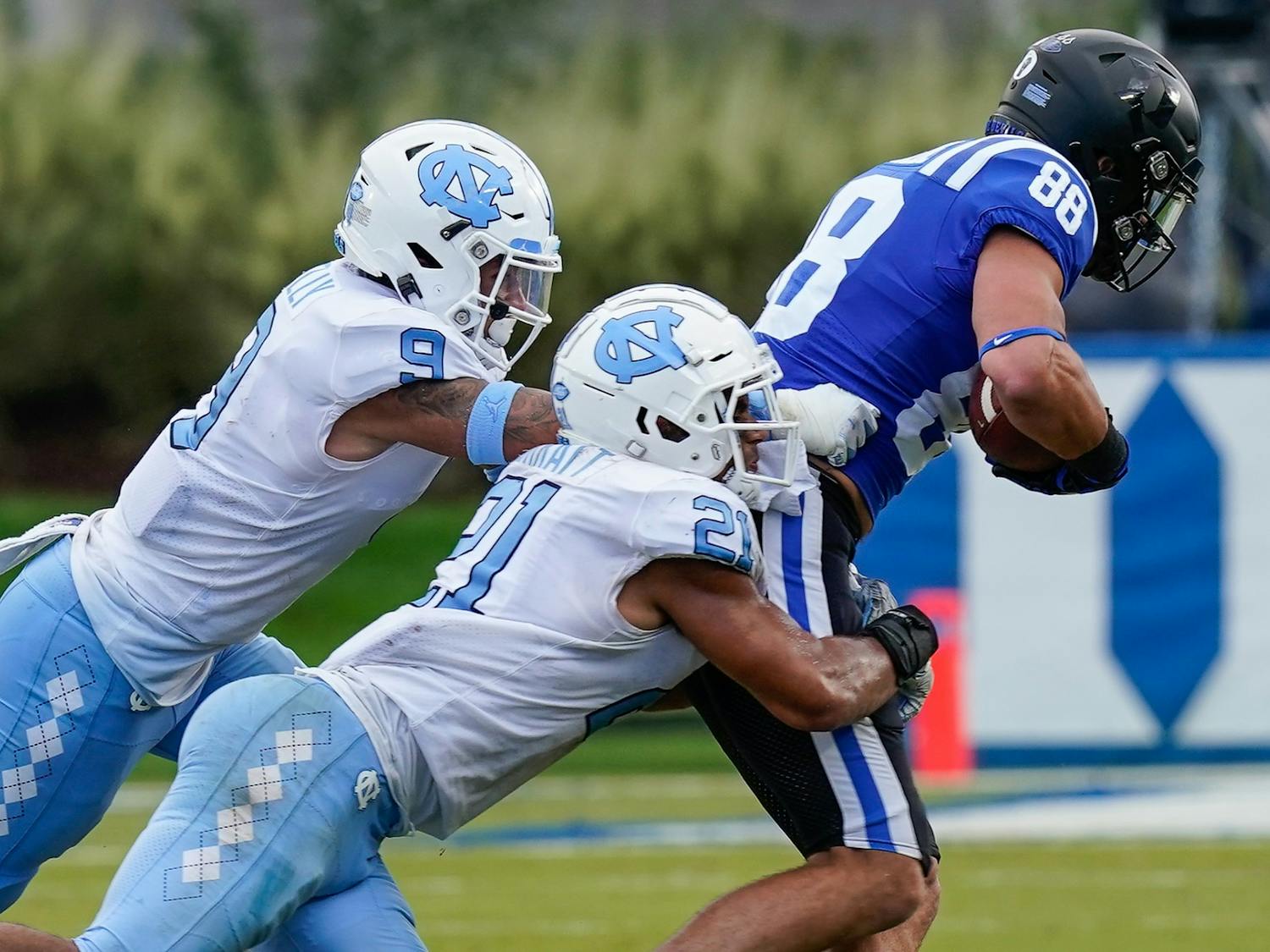 UNC linebacker Chazz Surratt (21) and defensive back Cam'Ron Kelly (9) tackle Duke tight end Jake Marwede (88) during the second half of the game at Wallace Wade Stadium on Saturday, Nov. 6, 2020. Photo courtesy of Jim Dedmon/Pool Photo-USA TODAY Sports