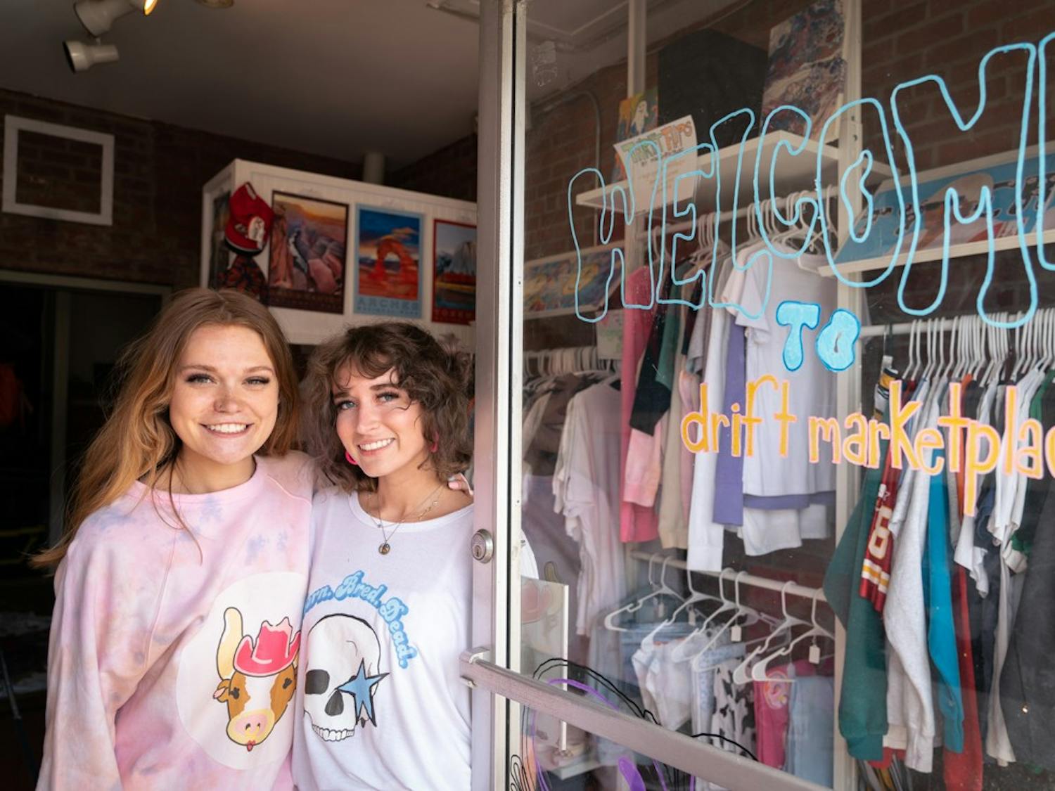 Cameron Griffin and Madelyn Birch stand at the entrance of Drift Marketplace on Tuesday, March 22, 2022. The two are the co-founders of MadGriffin Studio, a student-run art company.