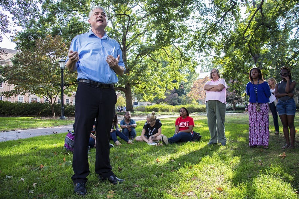Tim McMillan, senior lecturer in UNC's Department of African, African-American and Diaspora Studies, talks to students and local residents on the Black and Blue Tour about historical landmarks on campus related to UNC's racial history.