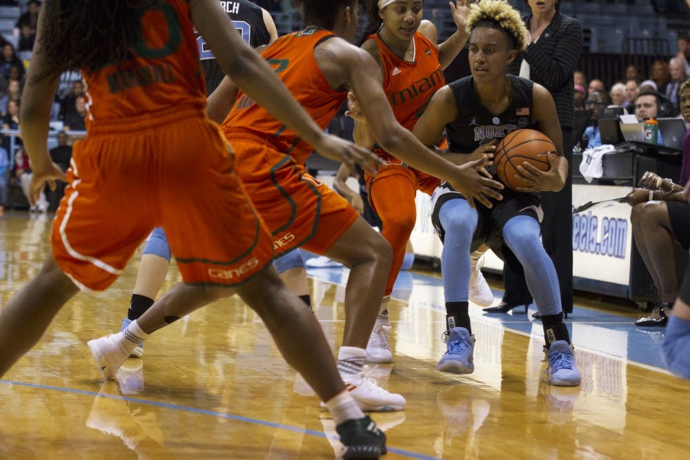 <p>Guard Paris Kea (22) is trapped by two Miami defenders during a Feb. 4 game in Carmichael Arena.</p>