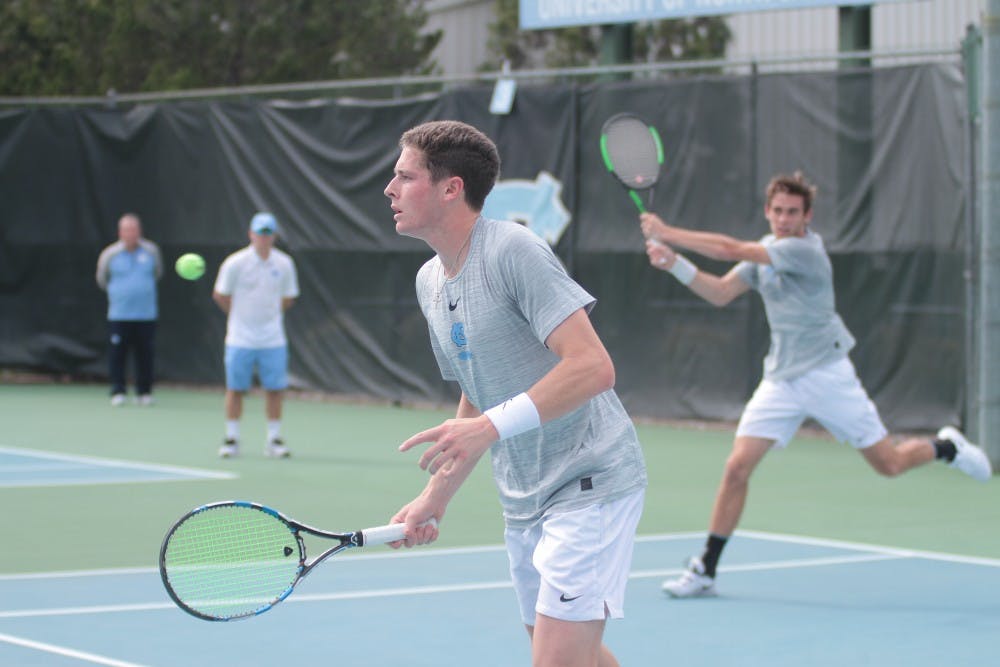 <p>Junior Blaine Boyden (front) and first-year Benjamin Sigouin (back) compete in doubles against Wake Forest on March 28 at the Cone-Kenfield Tennis Center.</p>