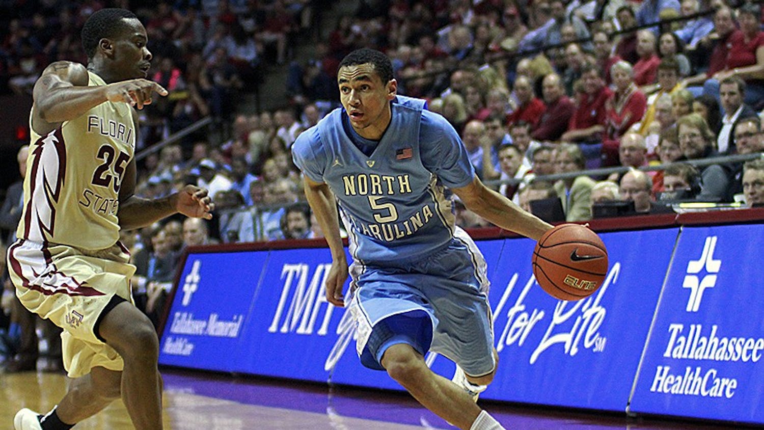 	Marcus Paige (5) drives toward the basket against Florida State&#8217;s Aaron Thomas (25). Paige finished the night with 20 points, 7 assists, and 4 steals.