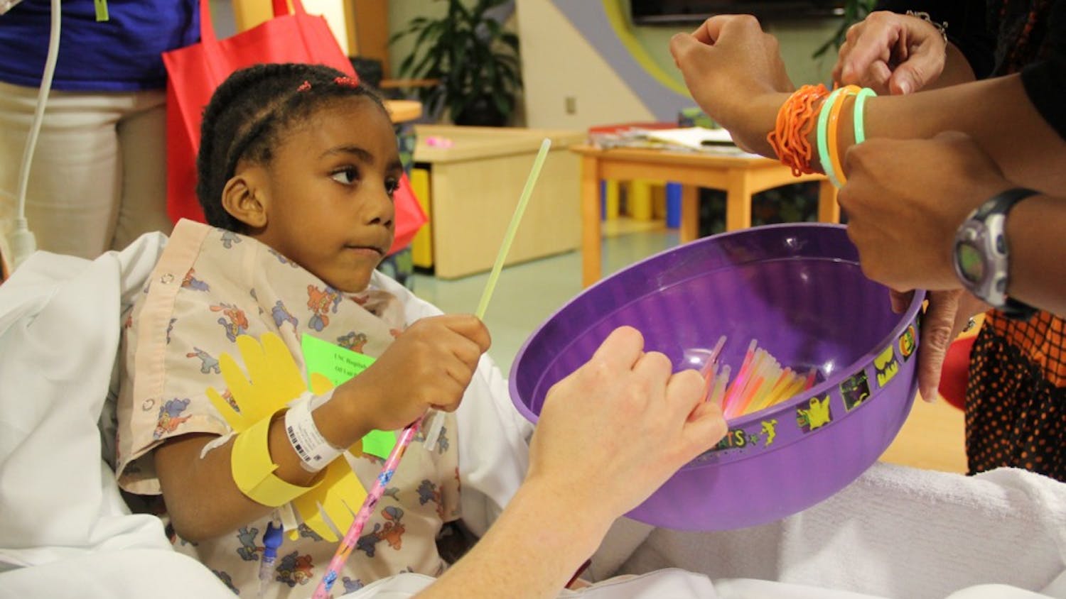Talyah Askew-Caldwell, 5, chooses a glowstick as she trick or treats the halls of UNC Children's Hospital.