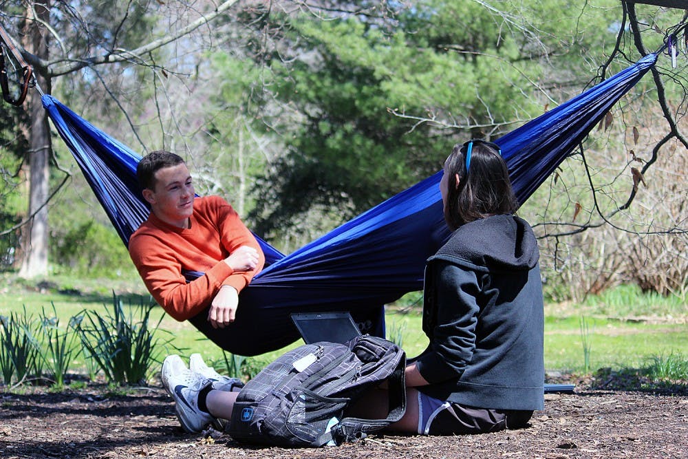 Patrick O'Neill, a sophomore business major, sits in his hammock in the Arboretum on Monday afternoon with Rachel Helms, a junior psychology major. 