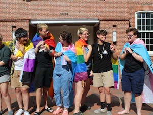 A group of students stand in front of Cobb Community on Sunday, Sept. 28, 2019. They hold flags for different groups within the LGBTQ+ community.