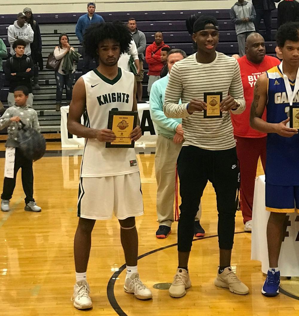 UNC 2018 commit Coby White (left) poses with Greenfield School's runner-up trophy on Dec. 30 at the John Wall Holiday Invitational in Raleigh.