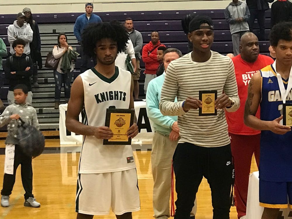 UNC 2018 commit Coby White (left) poses with Greenfield School's runner-up trophy on Dec. 30 at the John Wall Holiday Invitational in Raleigh.