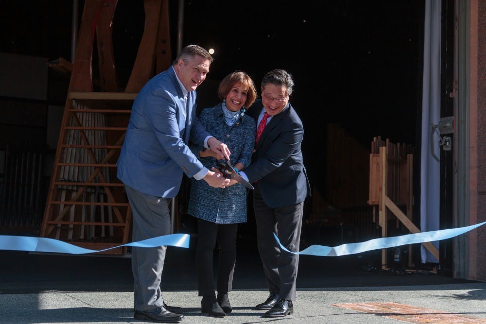 <p>(From left) Chapel Hill Downtown Partnership Chairman Scott Maitland, Chancellor Folt, and CPA Executive and Artistic Director Emil Kang cut the ribbon for the new CURRENT ArtSpace + Studio on Feb. 2, 2018.</p>