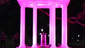 The Old Well stands illuminated with pink lights for the first time in honor of Breast Cancer Awareness month during the Pink out Polk Place event put on by the UNC Lineberger Comprehensive Cancer Center. The event included a fun run where the first 100 runners were covered in pink and blue powder. 