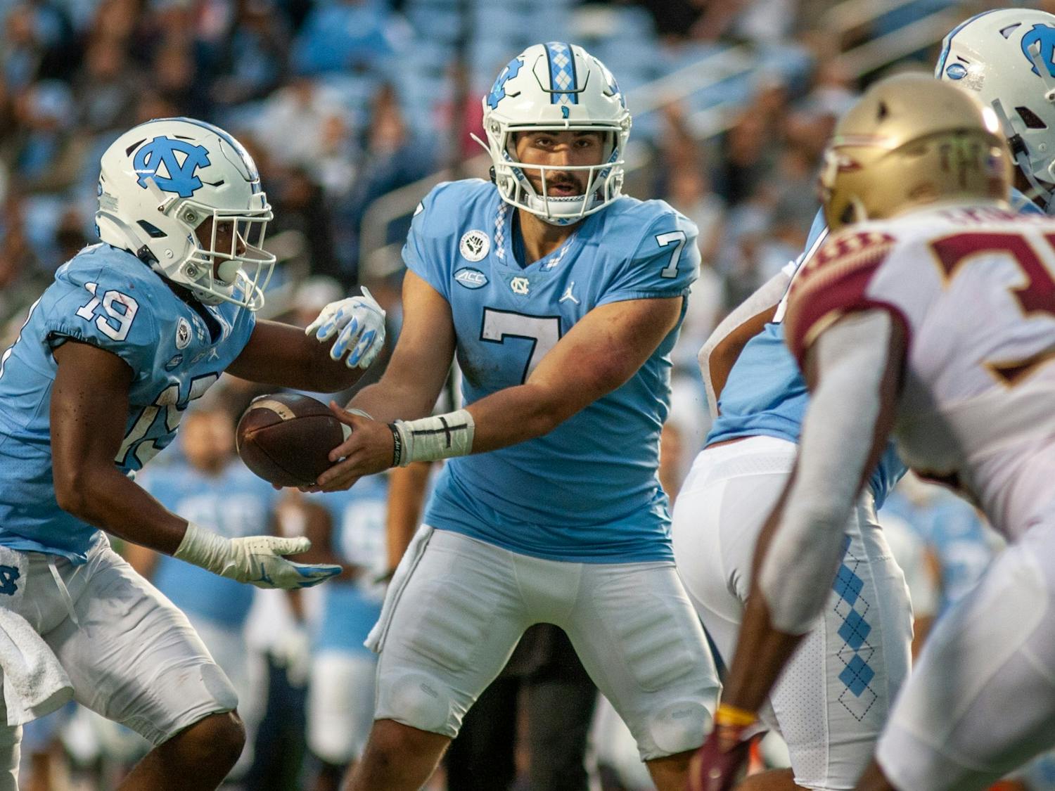UNC junior quarterback Sam Howell (7) hands the ball off graduate running back Ty Chandler (19) during the Tar Heels' home football game in Kena Stadium on Oct. 9 against the Florida State Seminoles. FSU won 35-25.