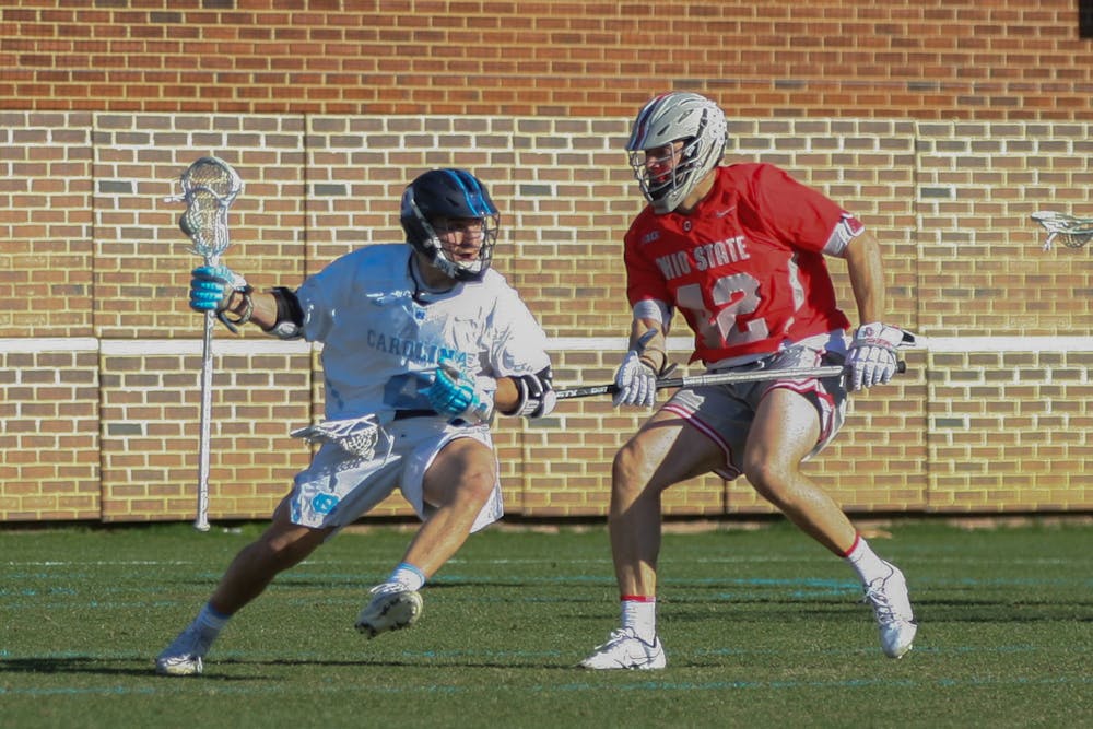 UNC graduate attacker Chris Gray (4) maintains possession during a home men's lacrosse game against Ohio State on Saturday, Feb. 19, 2022. UNC lost 20-8.