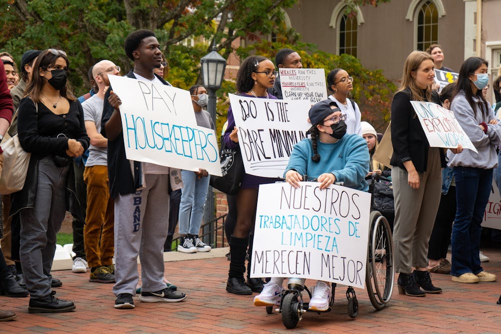 UNC students hold placards in support of the UNC Houseekepers March & Rally at the Old Well on Oct. 28, 2022.