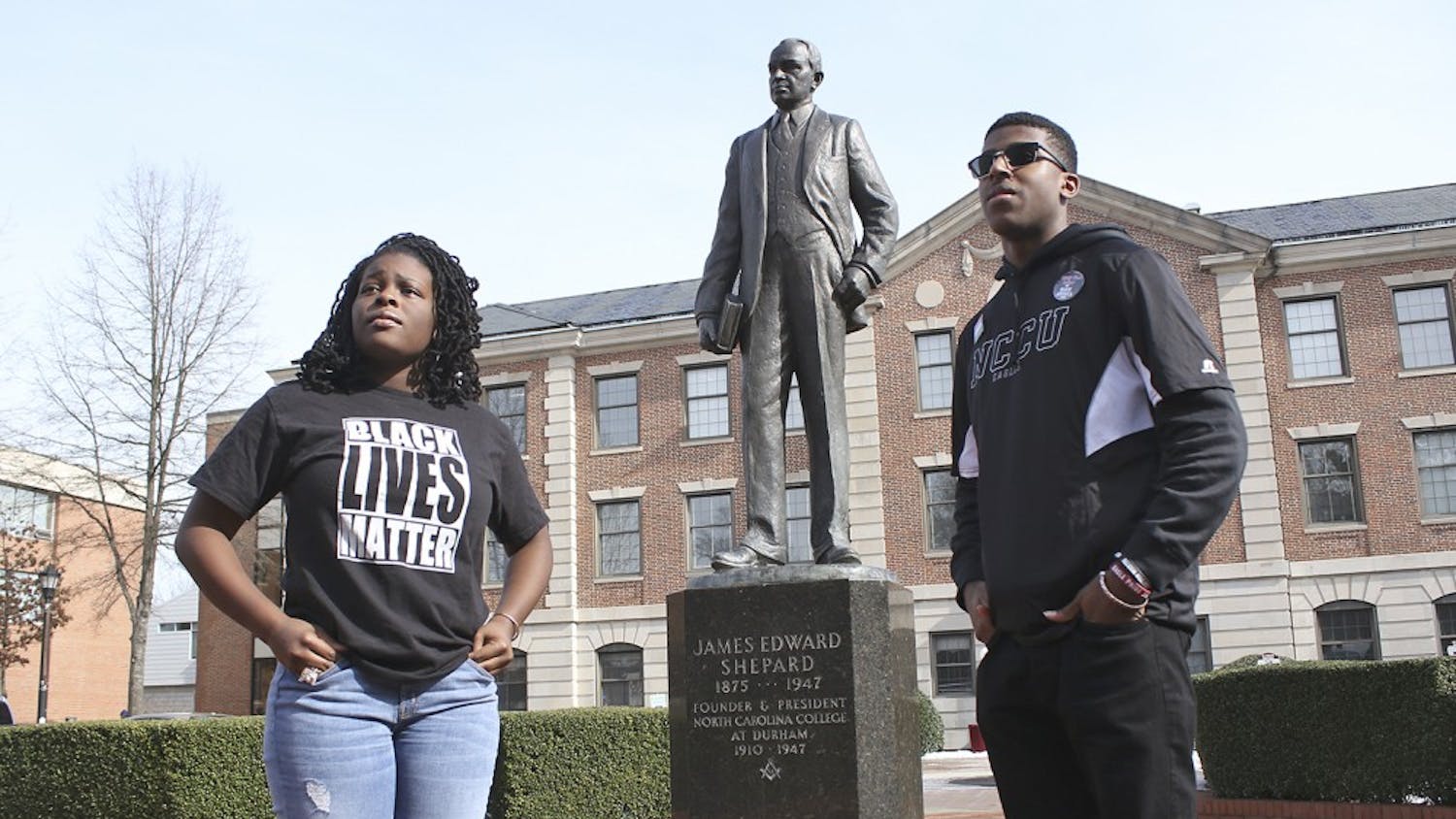 Raven Cheatham, a physical education major and Ajamu Dillahunt, a political science and history double major, both first-years at NC Central University, discuss their work as student activists. Cheatham and Dillahunt pose in front of the statue of James Shepard, founder of NCCU.