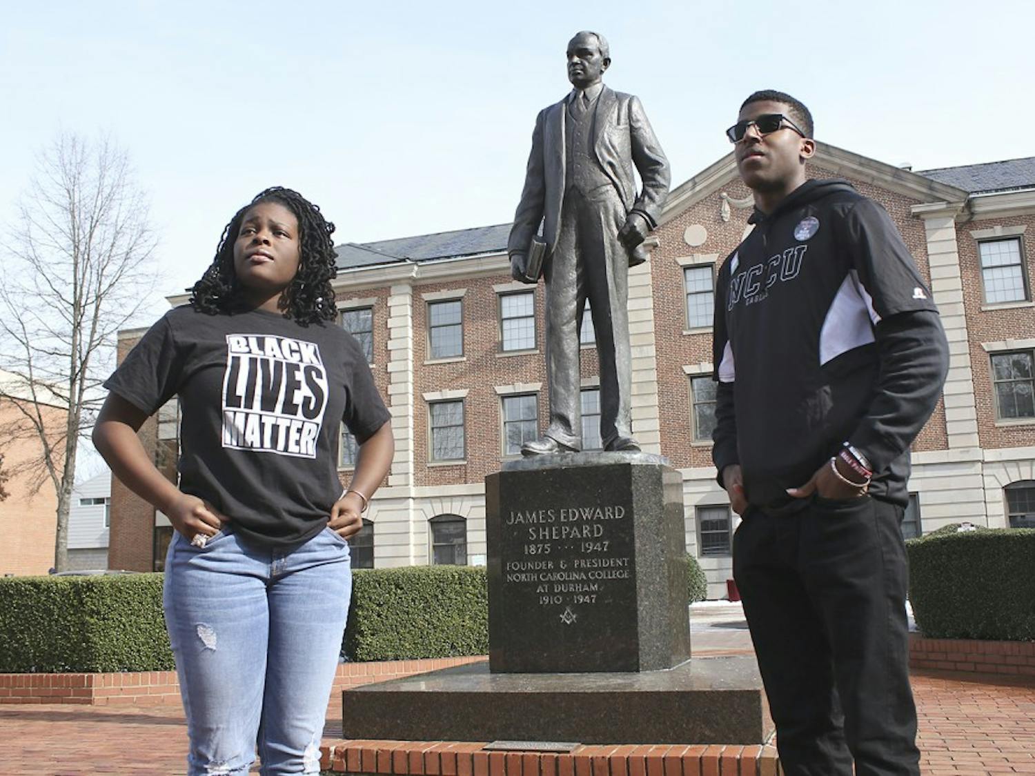 Raven Cheatham, a physical education major and Ajamu Dillahunt, a political science and history double major, both first-years at NC Central University, discuss their work as student activists. Cheatham and Dillahunt pose in front of the statue of James Shepard, founder of NCCU.