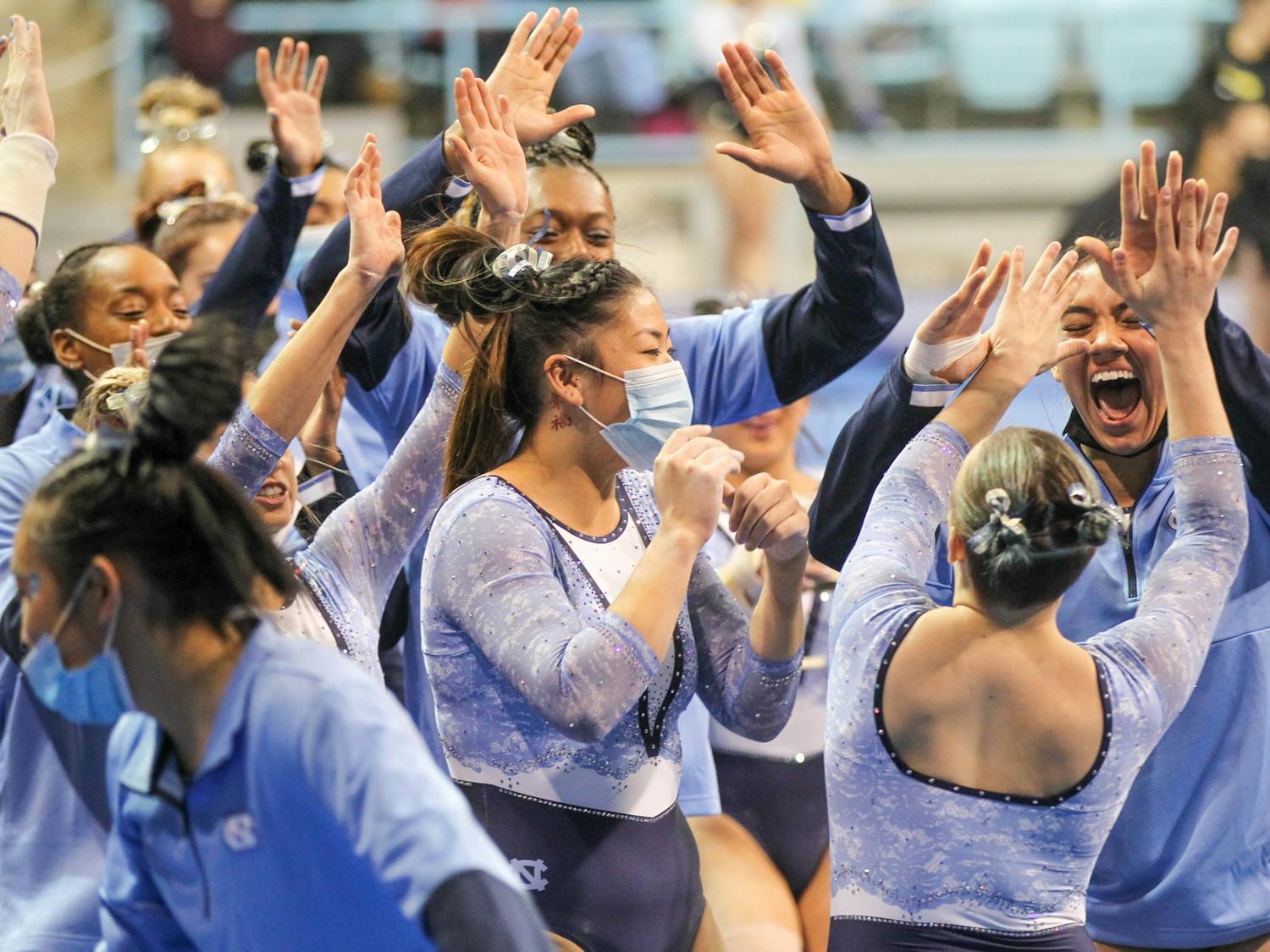 The team celebrates a successful vault by junior Jay Weil during UNC gymnastics' home meet on Saturday, Jan. 22, 2022, at Carmichael Arena.