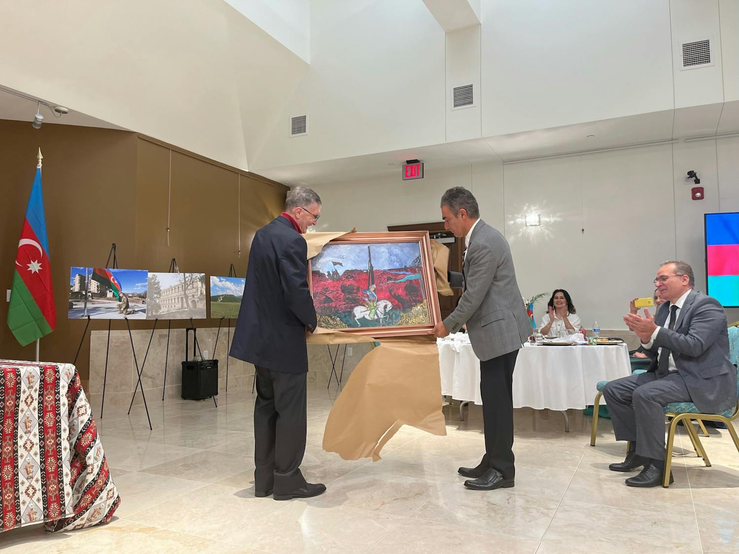 An organizer of the Azerbaijan Victory Day presents Turkish-American Nobel Peace Prize Winner, UNC graduate, and Sancar Center founder Aziz Sandra with a painting.