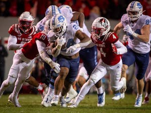 UNC senior running back British Brooks (24) attemtps to sprint past the defensive line during the Tar Heels' football game against the N.C. State Wolfpack at Carter Finley Stadium in Raleigh, NC, on Friday, Nov. 26, 2021. UNC lost 34-30.