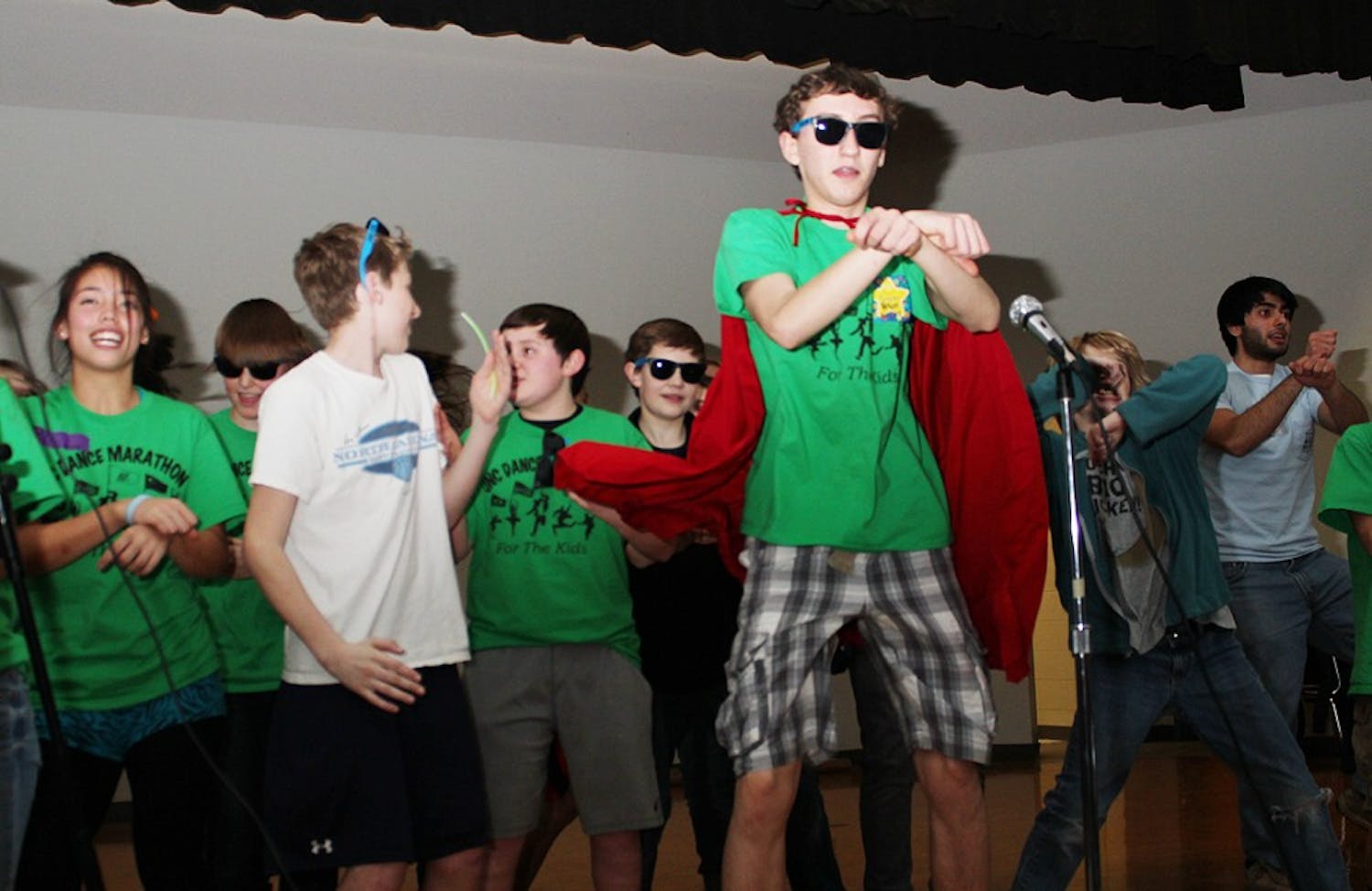 Dance Marathon hosted a Mini Dance Marathon at McDougal Middle School in Carrboro on Friday night. Austin Mejia, 14, (sunglasses and cape) leads dancers to the song Gangnam Style by Psi.