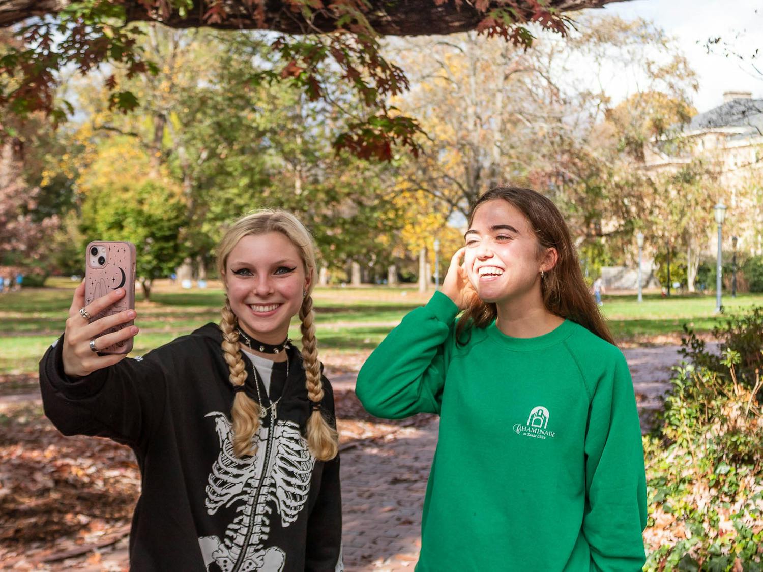 UNC first-year Mary Esposito and sophomore Ainsley Edwards pose together near the Old Well on Friday, Nov. 11, 2022.