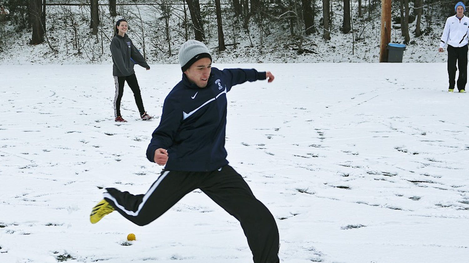 Freshmen Trevor Doane (right) and Megan NcNeill play soccer in the snow on Ehringhaus fields Tuesday. Classes were canceled at 2:30 p.m.
