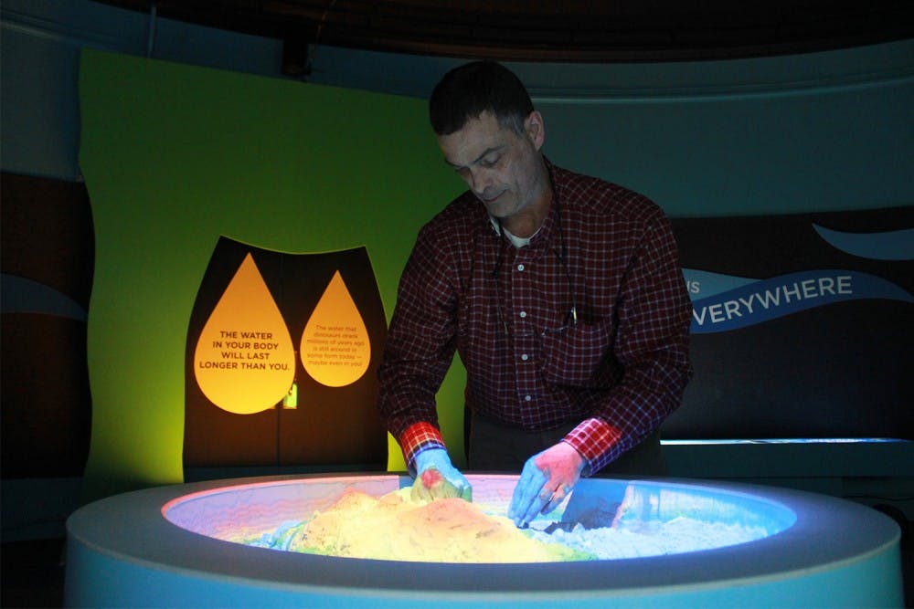 Dr. Todd Boyette, Director of Morehead Planetarium and Science Center, interacts with an augmented reality display in the Water in Our World exhibit.
