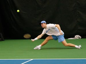 Senior Mac Kiger hits the ball during a match against Bucknell University at the Cone-Kenfield Tennis Center on Sunday, Jan. 23, 2022. The Heels won 7-0.