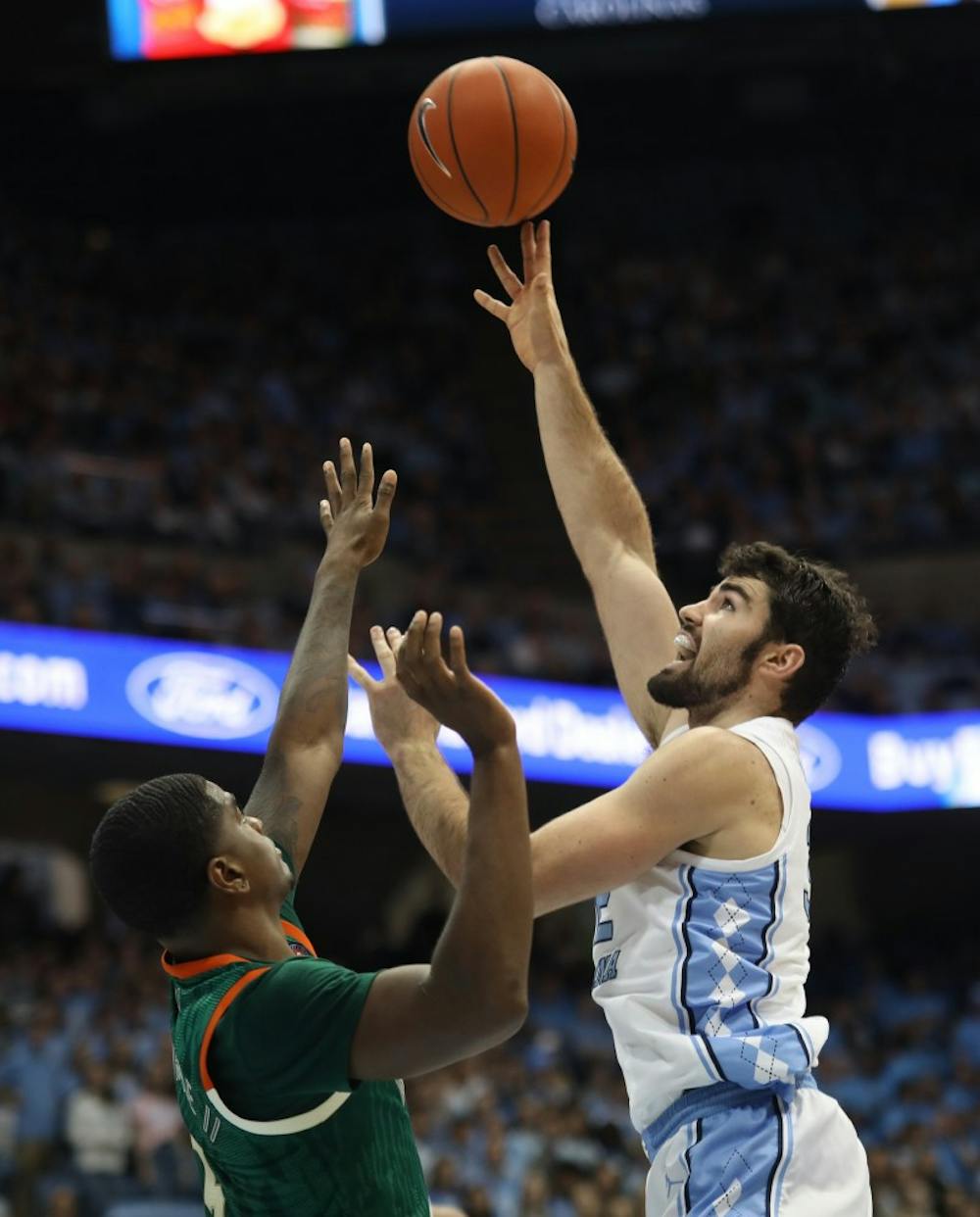 Miami senior guard Anthony Lawrence II (3) attempts to block a shot by UNC senior forward Luke Maye (32) on Saturday, Feb. 9, 2019 in the Smith Center. UNC men's basketball defeated Miami 88-85 in overtime. Maye scored 20 points for the Tar Heels.