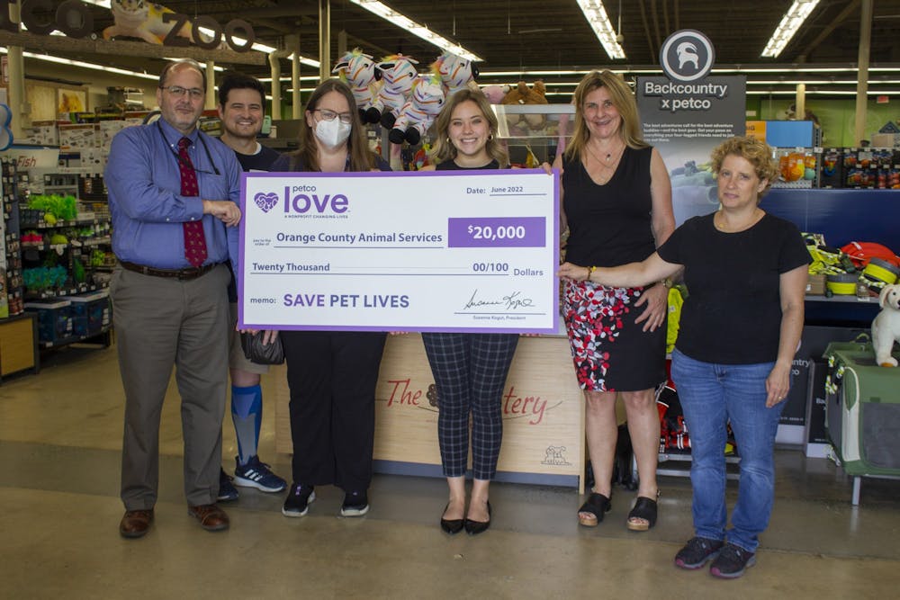 Store manager Chris Ponder presents the Orange County Animal Services staff with a $20,000 check inside the Petco on 1800 East Franklin Street on June 28, 2022.