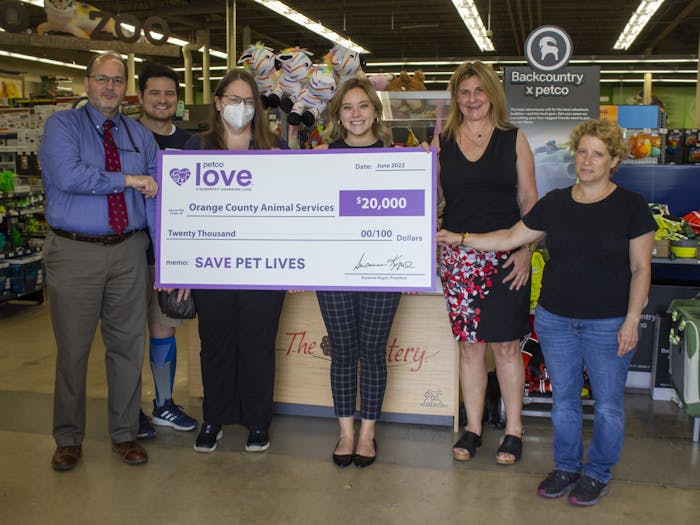 Store manager Chris Ponder presents the Orange County Animal Services staff with a $20,000 check inside the Petco on 1800 East Franklin Street on June 28, 2022.