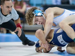 UNC first-year Spencer Moore holds down Queen's Melvin Rubio at the wrestling match on Nov. 1 at Carmichael Arena. UNC won 48-0.